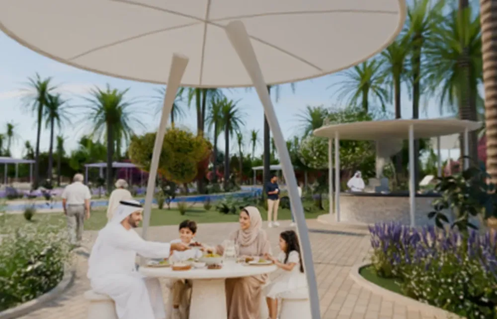A family at a table under a shade canopy in a park
